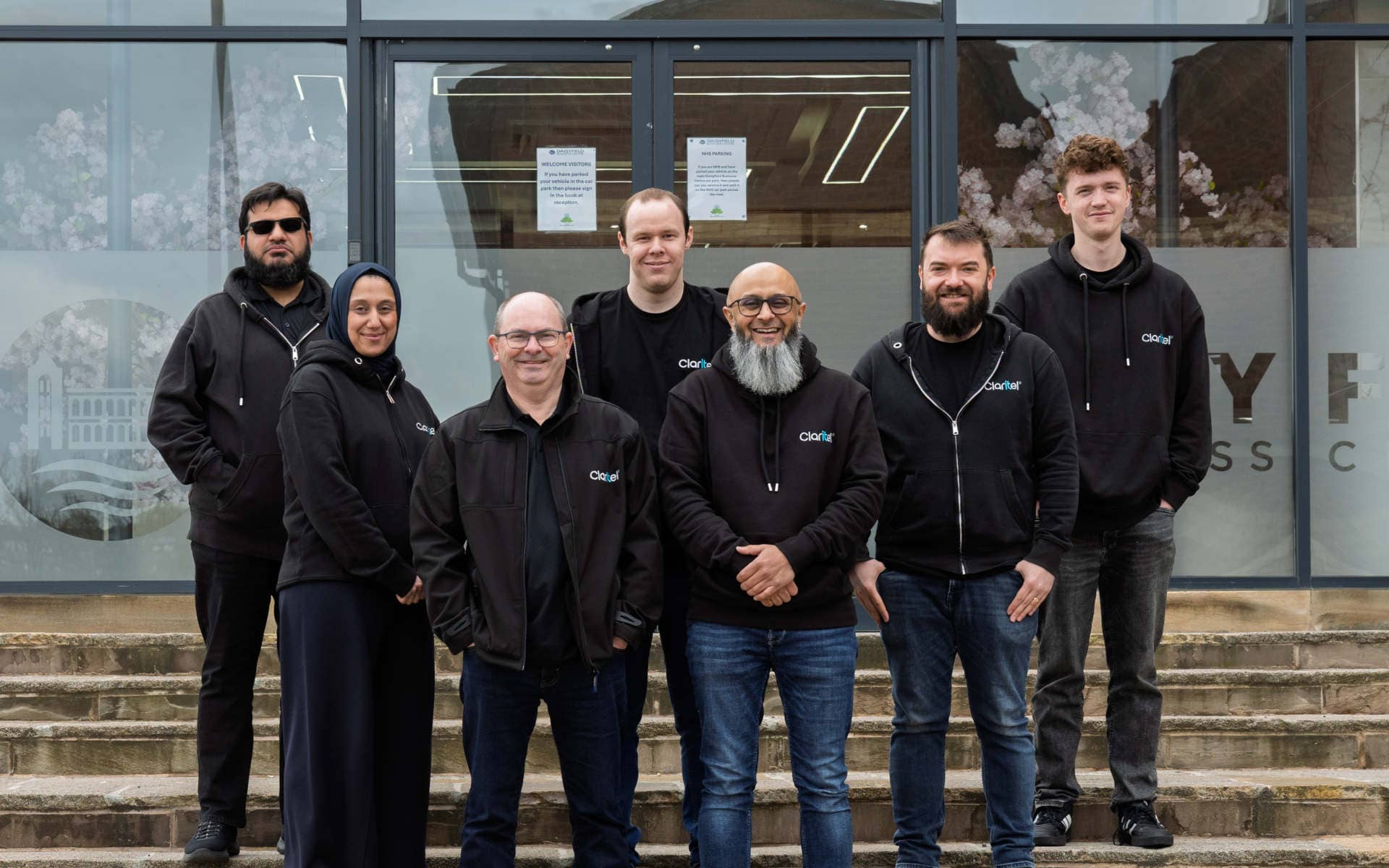 Photo of the Claritel team standing on the steps of the Daisyfield Mill Business Centre